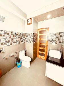 a bathroom with a toilet and a sink at Vista Resort - Managed BY The Four Season, Close to Manali Mall Road in Manāli