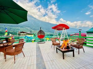 a patio with tables and chairs and a fire place at Vista Resort - Managed BY The Four Season, Close to Manali Mall Road in Manāli