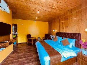 a bedroom with a large bed with a wooden ceiling at Vista Resort - Managed BY The Four Season, Close to Manali Mall Road in Manāli