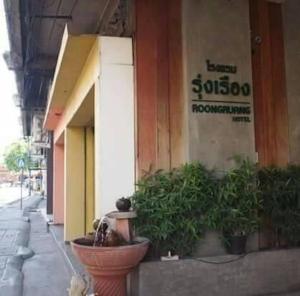 een hond zit buiten een gebouw bij Roongruang Hotel in Chiang Mai