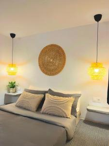 - une chambre avec un lit et deux lumières sur le mur dans l'établissement Aegean Serenity - Sea View Retreat, à Archangelos