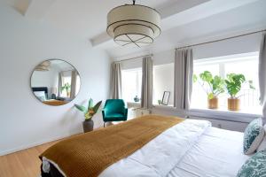 a bedroom with a large bed and a mirror at Penthouse-Nordic-Citycenter-Balcony in Copenhagen