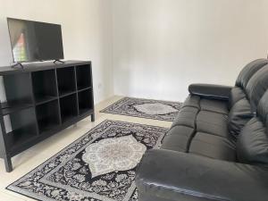 uma sala de estar com um sofá e uma televisão de ecrã plano em Rumah 2029 em Masjid Tanah