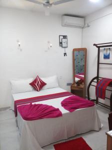 um quarto com uma cama com lençóis vermelhos e brancos em WISH RESIDENCE SEASIDE Colombo3 em Colombo