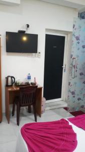 a bedroom with a desk and a table and a television at WISH RESIDENCE SEASIDE Colombo3 in Colombo