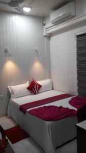 sypialnia z dużym białym łóżkiem z czerwonymi poduszkami w obiekcie WISH RESIDENCE SEASIDE Colombo3 w Kolombo