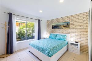 een slaapkamer met een bed en een raam bij 1 75 Rocky Point Road fantastic holiday home with in Fingal Bay