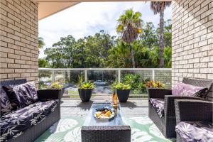 an outdoor patio with wicker furniture and a table at 1 75 Rocky Point Road fantastic holiday home with in Fingal Bay