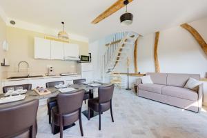 cocina y sala de estar con mesa y sofá en Maison avec Terrasse - 2 chambres confortables pour 4 à 6 personnes, en Verton