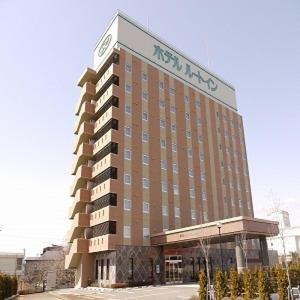 un bâtiment d'hôtel avec un panneau en haut dans l'établissement Hotel Route-Inn Aizuwakamatsu, à Aizuwakamatsu