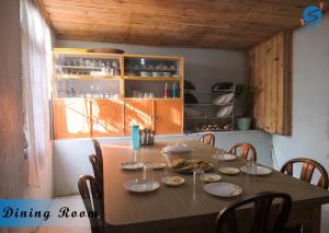 a dining room table with chairs and a kitchen at SAY Homes Grace in Namchi