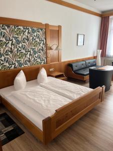 a bedroom with a large bed and a couch at Hotel Sonne by Mastiff in Bad Wildbad