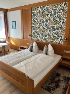 a large bed in a room with a wall at Hotel Sonne by Mastiff in Bad Wildbad