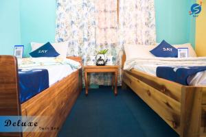 twee bedden naast elkaar in een kamer bij SAY Homes Grace in Namchi