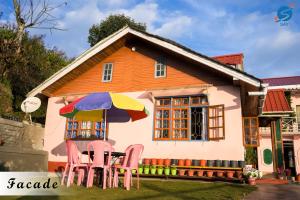 een klein huis met stoelen en een parasol bij SAY Homes Grace in Namchi