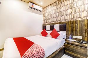 1 dormitorio con 1 cama con almohadas rojas en OYO Flagship Hotel Qubic, en Bombay