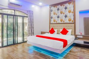 a bedroom with a large bed with red pillows at Collection O Hotel Rest Inn in Yeraoda