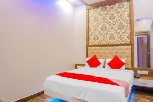 a bedroom with a large white bed with red pillows at Collection O Hotel Rest Inn in Yeraoda