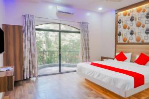 a bedroom with a bed and a large window at Collection O Hotel Rest Inn in Yeraoda