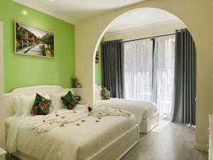 two beds in a room with green walls at Chez Mimosa Petite - Free Laundry in Ho Chi Minh City