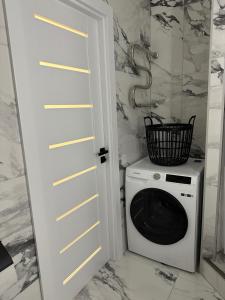 a laundry room with a washing machine and a door at AN apartment 2 in Rēzekne