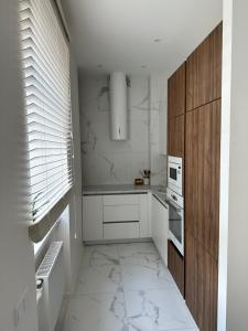a kitchen with white appliances and a white tile floor at AN apartment 2 in Rēzekne