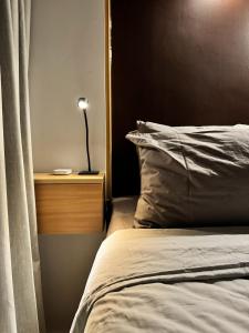 a bedroom with a bed and a lamp on a night stand at Stylish Staycation near BGC w/ Home Cinema in Manila