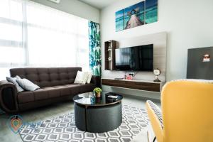 a living room with a couch and a tv at Jesselton Quay by Pinstay in Kota Kinabalu