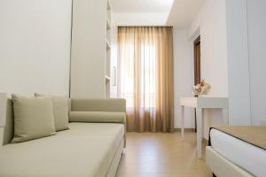 Sala de estar blanca con sofá y mesa en Hotel Vittoria, en Vasto
