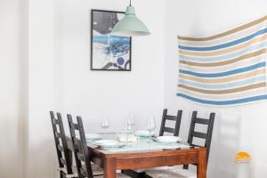 einen Esstisch mit Stühlen und eine Flagge an der Wand in der Unterkunft Apartamento Lavandula by Cadiz Time in Cádiz