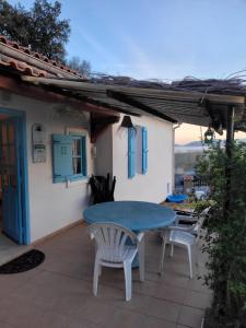 eine Terrasse mit einem blauen Tisch und 2 Stühlen in der Unterkunft Maison 4 face a la mer grand Jardin Ideal Famille avec pluri Animaux Saint Clair Le Lavandou in Le Lavandou