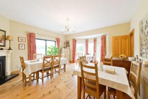 a kitchen and dining room with tables and chairs at Ash House Bed and Breakfast in Calverstown