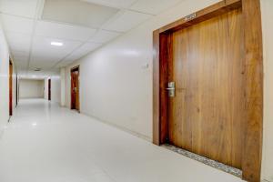 an empty corridor in an office building with a wooden door at OYO Hotel Address Inn in Mumbai