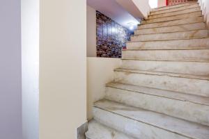 um conjunto de escadas num edifício com uma pintura na parede em OYO Perfect Inn em Nova Deli
