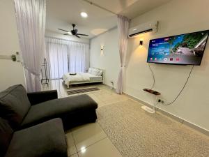 a living room with a couch and a flat screen tv at The Borneo Suite, 5 mins to Airport, 6-10 Guests , 2 FREE CAR PARKS in Kota Kinabalu