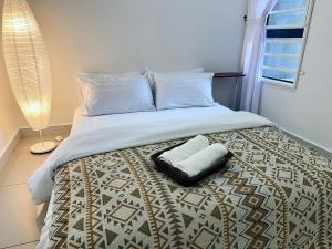 a bedroom with a bed with a pillow on it at The Borneo Suite, 5 mins to Airport, 6-10 Guests , 2 FREE CAR PARKS in Kota Kinabalu