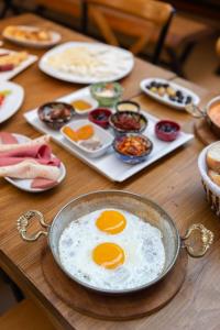a table with a pan with eggs on it at Rose Apartments in Istanbul