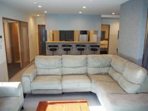 新潟市にあるHoliday Villa ボストンのリビングルーム(白いソファ付)、キッチンが備わります。