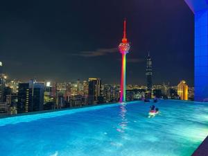吉隆坡的住宿－Platinum Sky Park Kuala Lumpur，在一个城市天际线的游泳池里,晚上