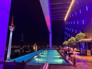 a swimming pool with a view of the space needle at night at Platinum Sky Park Kuala Lumpur in Kuala Lumpur