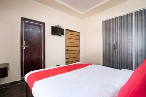 a bedroom with a bed with a red and white blanket at OYO Seera Enclave in Rājahmundry