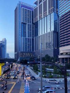 吉隆坡的住宿－Platinum Sky Park Kuala Lumpur，一条繁忙的城市街道,高楼前有交通