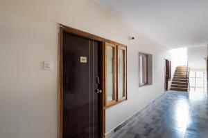 a room with a door and a hallway with stairs at OYO Seera Enclave in Rājahmundry