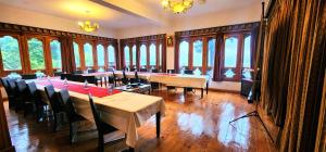 een grote kamer met tafels, stoelen en ramen bij Tiger's Nest Resort - Best Resort In Paro in Paro