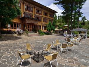 a patio with tables and chairs in front of a building at Tiger's Nest Resort - Best Resort In Paro in Paro