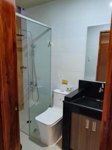 een badkamer met een toilet en een glazen douche bij Norlu Cedec Midpoint Hotel in Rosario