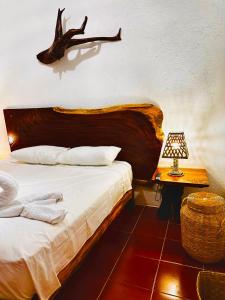 a bedroom with a bed and a table with a lamp at La Casa de Colores Ocean View in Puerto Ángel +63 photos