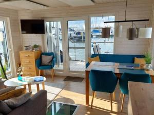 a living room with a table and blue chairs at Houseboat Hecht in Egernsund at the Marina Minde in Egernsund