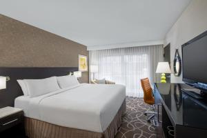 a hotel room with a large bed and a television at Crowne Plaza Kitchener-Waterloo, an IHG Hotel in Kitchener