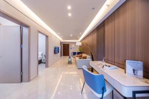 ein Büro mit einem Schreibtisch und ein Zimmer mit einem Bett in der Unterkunft Excellence International Apartment - Convention & Exhibition Center in Shenzhen